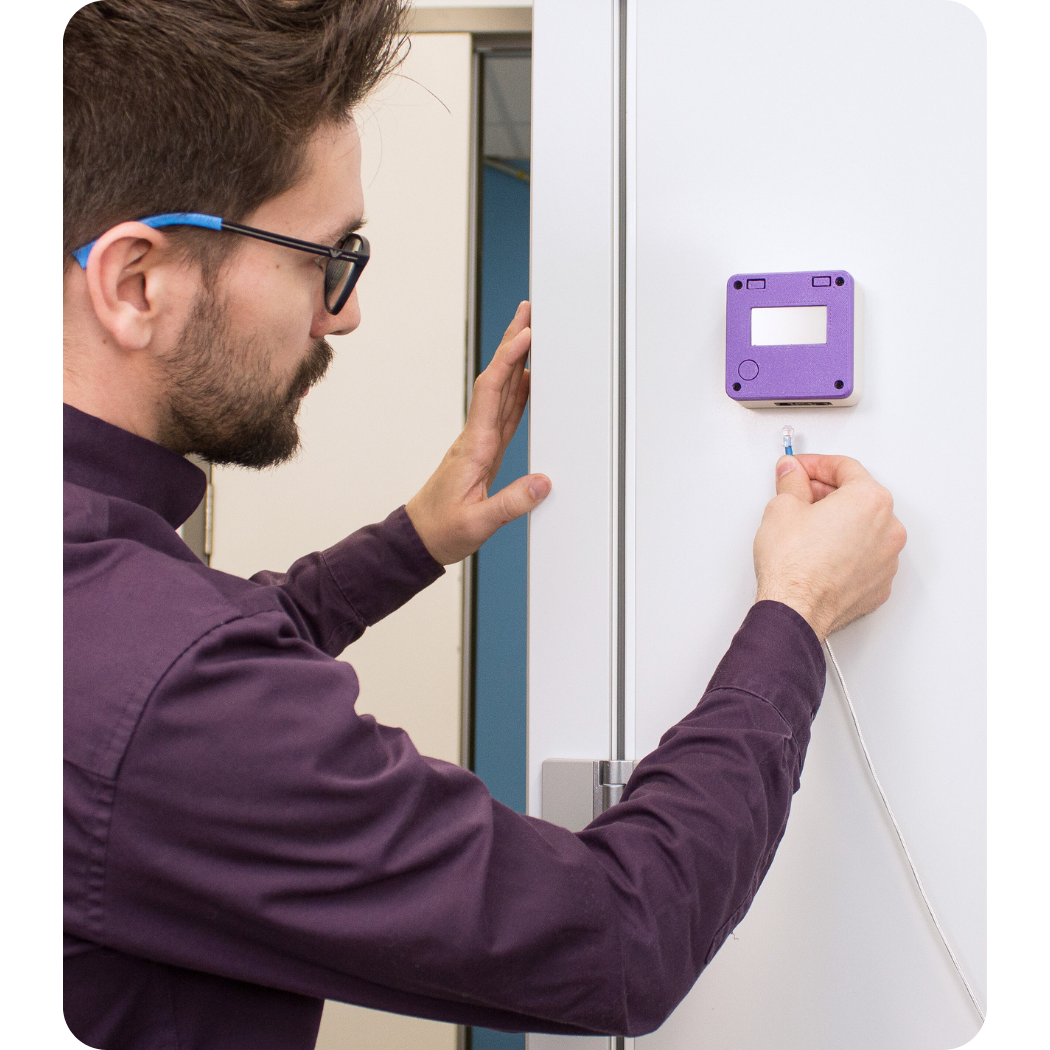 ATEK technician installing a cabling system for commissioning monitoring sensors.