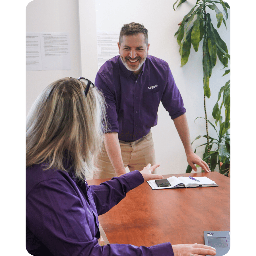 Two ATEK employees having a discussion during an interview in a collaborative work environment.