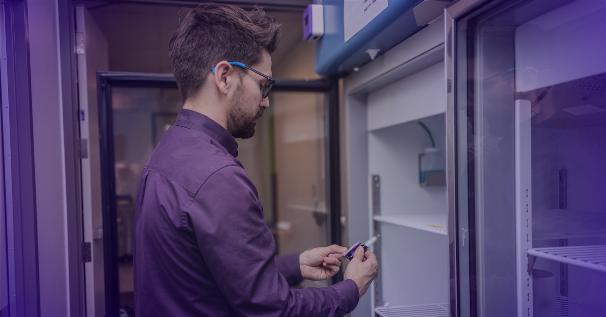 Technician installing a temperature probe in a laboratory refrigerator for ATEK monitoring system.
